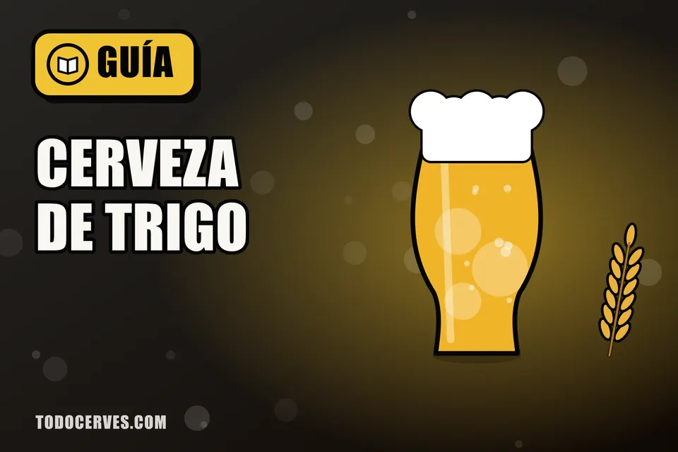 Vaso alto de cerveza de trigo turbia con espuma abundante junto a una espiga de trigo